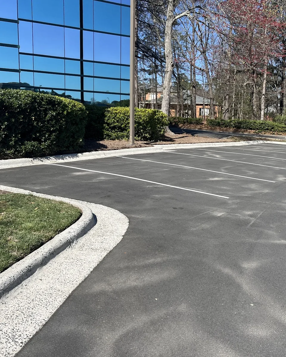 Parking spaces and curb beside a glass commercial building