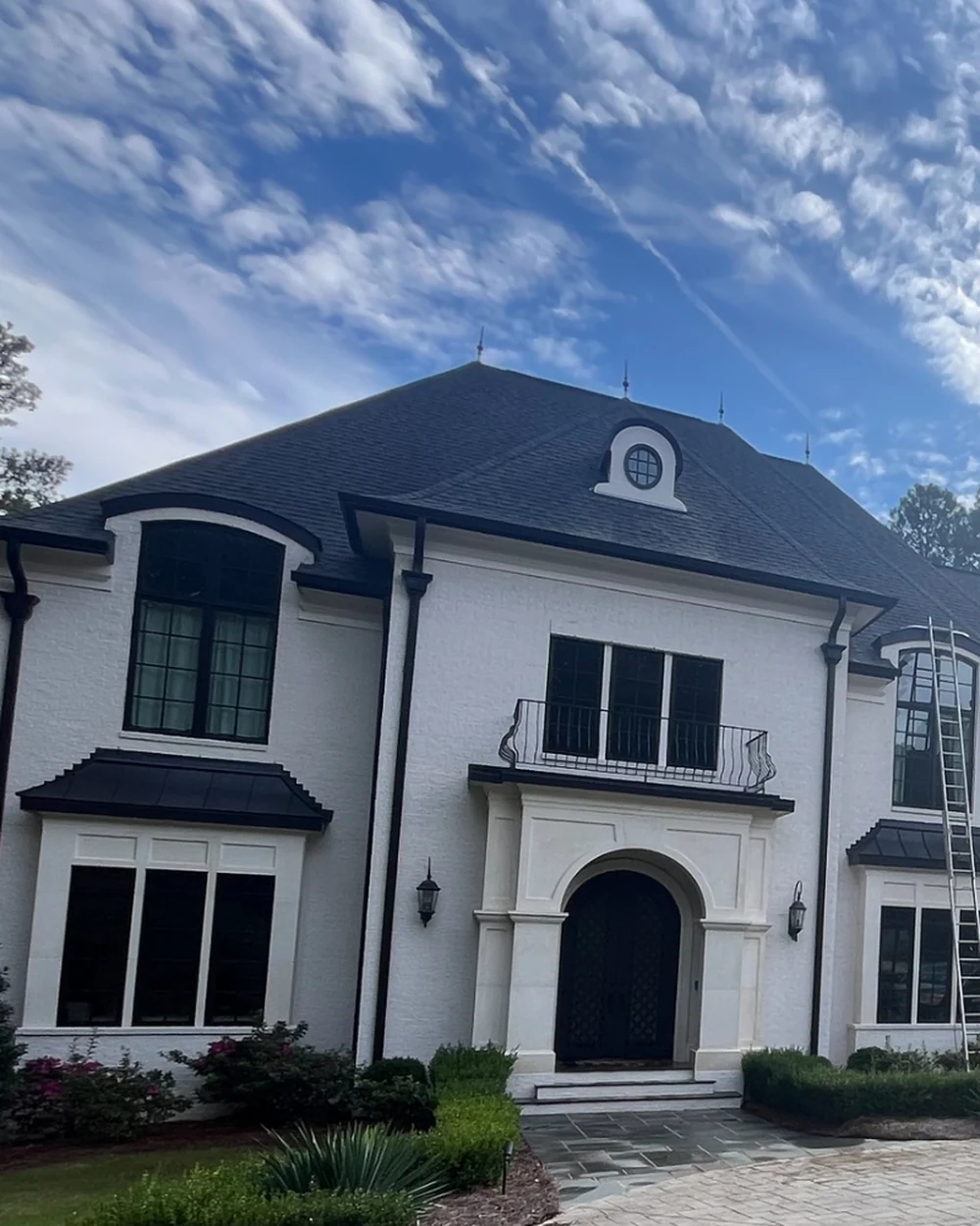 Ladders positioned along a Durham-area home for exterior cleaning